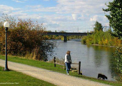 Picture of a lady walking her dog on the River Front Trail in Missoula, Montana.