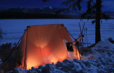 February night picture of a tent near a snow covered Seeley Lake. Image is from the Seeley Lake, Montana Winter Picture Tour.