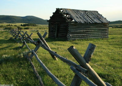 June picture of an abandoned log cabin and Pintlar Mountains in the Mount Haggin Wildlife Management Area. Image is from the Mount Haggin WMA Picture Tour.