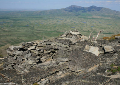 June picture of one of the ancient the rock structures and a hiker on the summit of Gold Butte (6512 feet) and East Butte. Image is from the Sweet Grass Hills Montana Picture Tour.