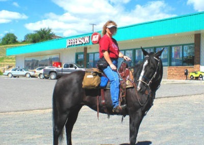 August picture of a lady riding horseback in the IGA Store Parking Lot in Whitehall, Montana. Image is from the Whitehall Montana Picture Tour.
