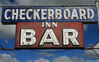 June 2018 picture of the Checkerboard Bar Sign along Highway 12. Image is from the Checkerboard Montana Picture Tour.