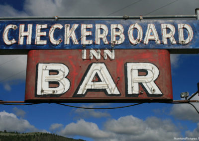 June 2018 picture of the Checkerboard Bar Sign on Highway 12. Image is from the Checkerboard Montana Picture Tour.
