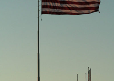 July sunset picture of the Veteran’s Flag in Shelby Montana Image is from the Shelby Montana Picture Tour.