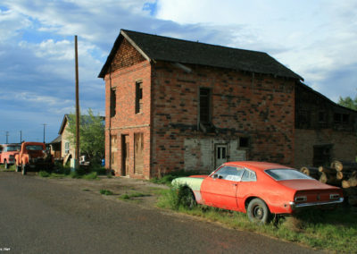 June picture of an abandoned building and Ford Pinto car. Image is from the Toston Montana Picture Tour.