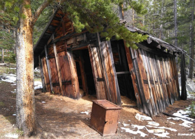 June picture of leaning log cabin in the Coolidge Ghost town. Image is from the Coolidge Montana Picture Tour.