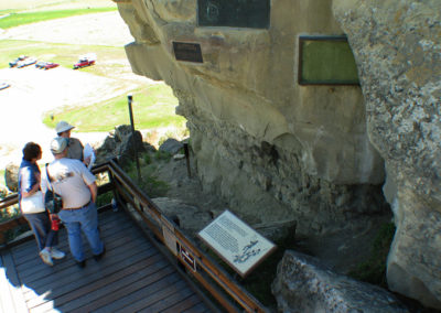 June picture of tourist inspecting William Clark’s signature at Pompey’s Pillar. Image is from the Pompey’s Pillar Picture Tour.