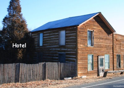 January picture of the two-story log cabin Hotel with a clap board front in Radersburg, Montana